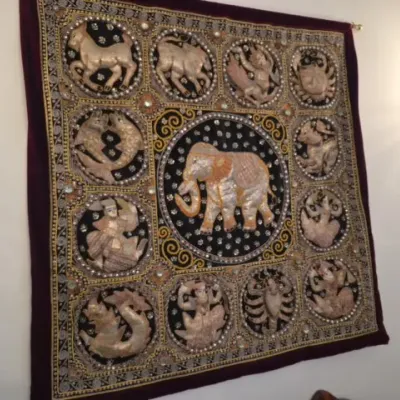 Sale Photo Thumbnail #70: Traditional Kalaga embroidered tapestry featuring a central elephant surrounded by figures and animals, detailed with metallic threads and sequins on a dark background.
