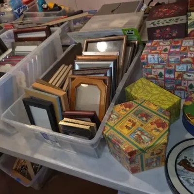 Sale Photo Thumbnail #161: Assortment of picture frames in clear plastic storage bins displayed alongside decorative gift boxes and holiday tins.