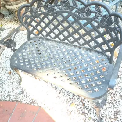 Sale Photo Thumbnail #175: Black cast aluminum outdoor garden bench featuring a rose motif backrest and lattice seat.
