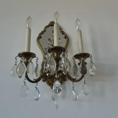 Sale Photo Thumbnail #84: Vintage French Provincial-style brass three-light wall sconce featuring a mirrored backplate and teardrop crystal prisms.