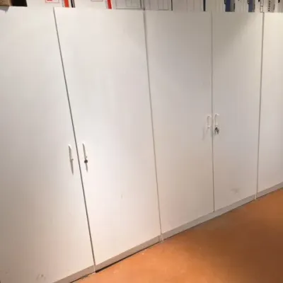 Sale Photo Thumbnail #148: Large bank of modern white laminate storage cabinets featuring lockable double doors with key inserts and simple white handles.