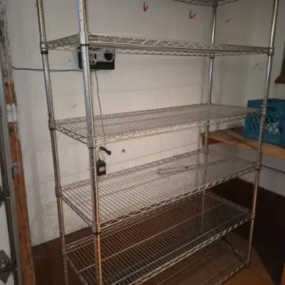 Sale Photo Thumbnail #150: Tall metal wire shelving unit with six adjustable tiers, ideal for garage or basement storage.
