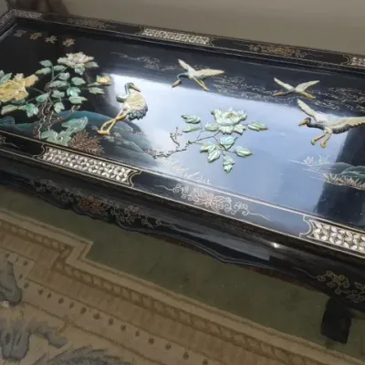 Sale Photo Thumbnail #22: Vintage Asian black lacquer coffee table featuring carved mother-of-pearl and soapstone relief details of cranes and flowers, framed by mother-of-pearl geometric inlay.