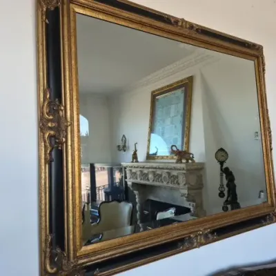 Sale Photo Thumbnail #78: Large ornate wall mirror featuring a gilt and black painted molded frame with corner scroll accents.