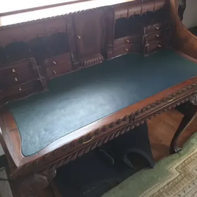 Sale Photo Thumbnail #21: Antique carved mahogany writing desk featuring a green leather inset top, detailed rope-twist edging, and a raised gallery with small drawers and compartments.