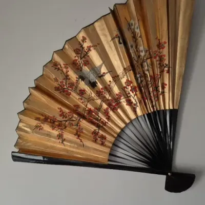 Sale Photo Thumbnail #74: Vintage Asian decorative wall fan featuring hand-painted red blossom branches and flying cranes on a gold-tone paper background with black lacquer ribs.