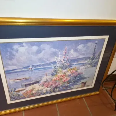 Sale Photo Thumbnail #66: Large framed impressionist-style art print depicting a coastal landscape with vibrant flowers, double-matted in a metallic gold frame.