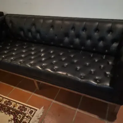 Sale Photo Thumbnail #27: Mid-century modern black leather tufted sofa featuring a sleek tuxedo silhouette and a chrome base.