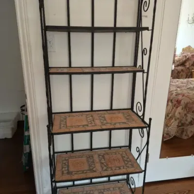 Sale Photo Thumbnail #58: Black wrought iron baker's rack featuring decorative scrollwork and sun-motif mosaic tile shelves.