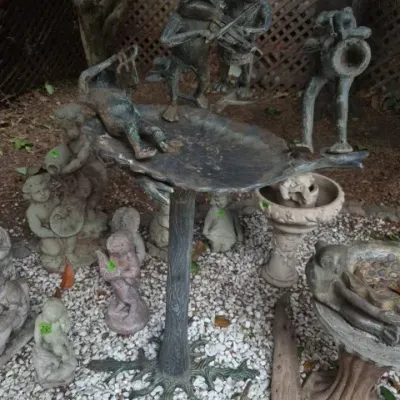 Sale Photo Thumbnail #185: Cast bronze bird bath with musical frog statues, surrounded by various concrete garden ornaments and statues.