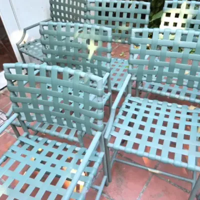 Sale Photo Thumbnail #177: Set of sage green vintage patio chairs featuring woven vinyl strap seats and backs on metal frames.