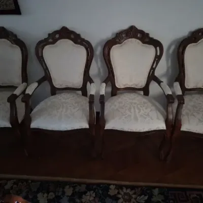 Sale Photo Thumbnail #6: Set of four Victorian-style carved dark wood armchairs upholstered in a cream damask fabric.