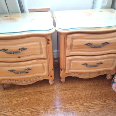 Sale Photo Thumbnail #52: Pair of French Provincial style light pine nightstands featuring two drawers with dark metal hardware and glass protective tops.