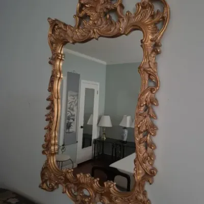 Sale Photo Thumbnail #79: Large vintage Rococo-style wall mirror with an ornate gilded frame and elaborate scrollwork detail.