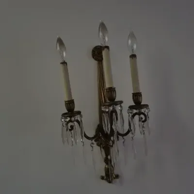 Sale Photo Thumbnail #86: Traditional three-light brass wall sconce adorned with hanging crystal prisms and faux-candle sleeves.