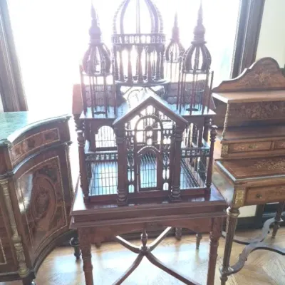Sale Photo Thumbnail #16: Elaborate Victorian-style architectural wooden birdcage on a matching legs stand, featuring ornate spires and domed towers.