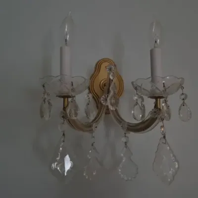 Sale Photo Thumbnail #87: Vintage two-light crystal wall sconce with a gilt backplate and hanging glass prism drops.