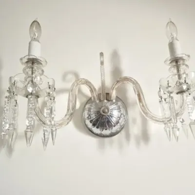 Sale Photo Thumbnail #83: Vintage two-arm crystal wall sconce featuring curved glass arms, dangling prism icicles, and a silver-tone backplate.
