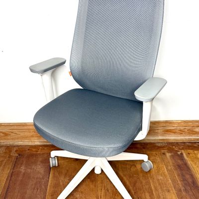 Modern grey mesh office desk chair with white frame, adjustable armrests, and rolling caster base.