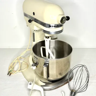 Vintage off-white KitchenAid Hobart bowl-lift stand mixer with stainless steel mixing bowl, wire whisk, dough hook, and flat beater...