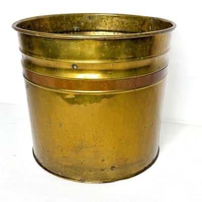 Vintage brass and copper planter bucket featuring a rolled rim and aged patina throughout.