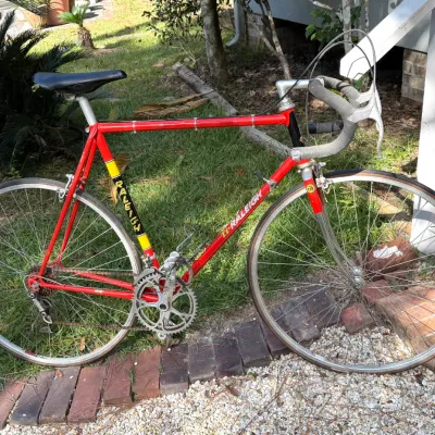 Vintage red TI-Raleigh 10-speed road bicycle featuring drop handlebars, original decals, and chrome details.