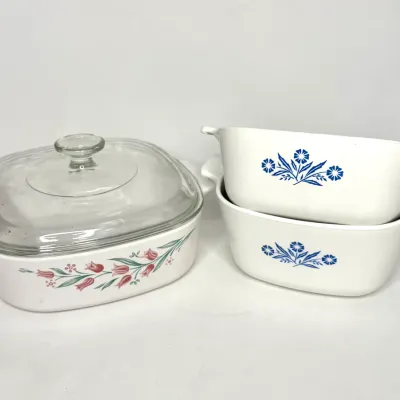 Set of three vintage Corning Ware casserole dishes, including two with the classic Cornflower Blue pattern and one with a pink floral...