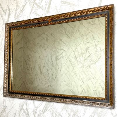Large vintage wall mirror in an ornate carved giltwood frame with egg-and-dart detailing and black painted accents.