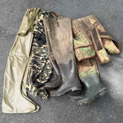 Collection of vintage hunting and fishing hip waders and chest waders, featuring canvas rubber boots and camouflage patterns.