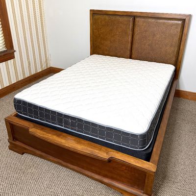 Wooden bed frame with an upholstered leatherette headboard, including mattress and box spring set.