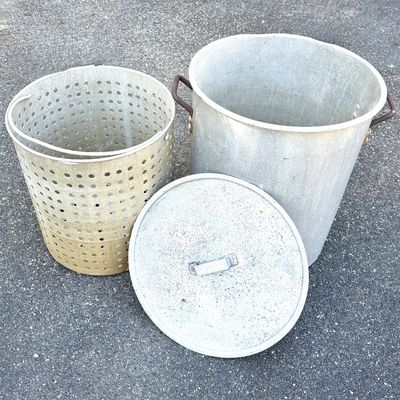 Large vintage aluminum outdoor turkey fryer or seafood boil pot with a matching strainer basket insert and lid.