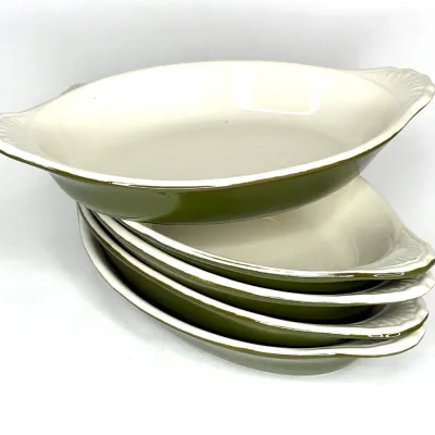 Stack of six vintage olive green and off-white ceramic oval au gratin baking dishes with textured tab handles.