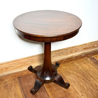 Traditional mahogany pedestal side table featuring a round top and a four-star base with scrolled feet.