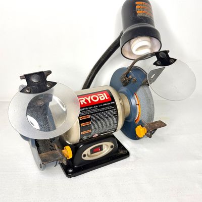 Ryobi model BGH6110 6-inch bench grinder equipped with clear eye shields and an attached gooseneck work light.