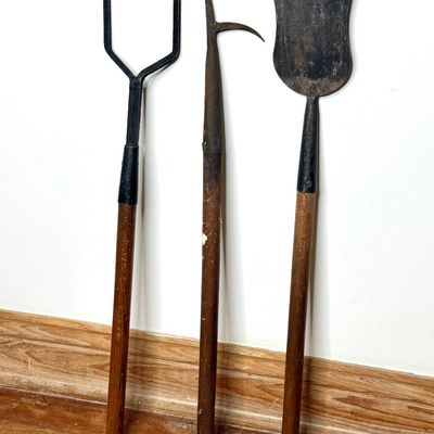 Set of three vintage long-handled specialty tools, including a pitchfork-style hook, a pike pole, and a broad-bladed spade, all featuring...