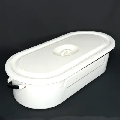 Vintage white enamelware fish poacher with lid and black trim, showing minor chips near the handle.