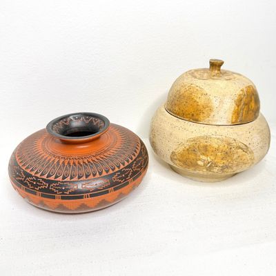 Two studio pottery pieces, including a low Southwest-style terracotta vessel with intricate black geometric etching and a beige lidded...