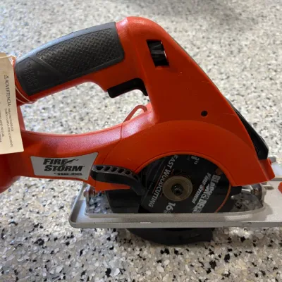 Sale Photo Thumbnail #8: Black & Decker FireStorm cordless circular saw with an attached wood-cutting blade and price tag.