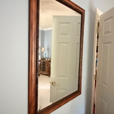 Sale Photo Thumbnail #275: Large rectangular wall mirror in a dark reddish-brown wood frame with carved inner trim.