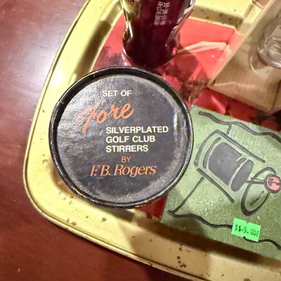 Sale Photo Thumbnail #168: Vintage set of Four silverplated golf club drink stirrers by F.B. Rogers, housed in their original branded container on a bar tray.
