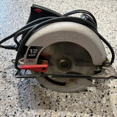 Sale Photo Thumbnail #59: Skilsaw 12 Amp 7 1/4-inch corded circular saw with blade attached, showing minor signs of cosmetic wear.
