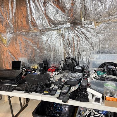 Sale Photo Thumbnail #200: Large assortment of vintage and modern electronics, including Toshiba and other laptops, computer keyboards, cables, remotes, and accessories arranged on folding tables.