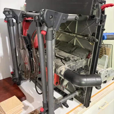 Sale Photo Thumbnail #71: Milwaukee portable jobsite table saw with folding rolling stand, showing light sawdust and signs of use.
