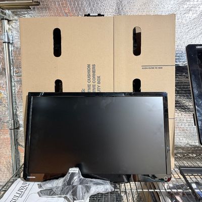 Sale Photo Thumbnail #210: Toshiba black flat-screen television monitor with its plastic-wrapped base stand displayed on a wire shelf.