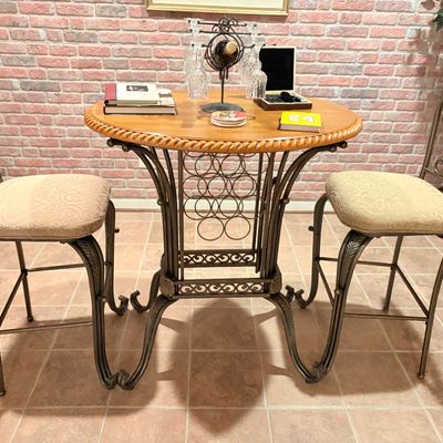 Sale Photo Thumbnail #248: Wrought iron pub table set featuring a rope-edge wood top, integrated wine rack base, and two matching scrollback barstools with upholstered seats.