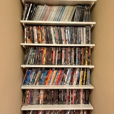 Sale Photo Thumbnail #170: Seven-tier white wall-mounted shelving unit fully stocked with a large collection of DVDs and Blu-ray movies.