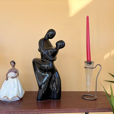 Sale Photo Thumbnail #126: Collection of tabletop decor including a porcelain dancer figurine, a glossy black ceramic abstract dancing couple sculpture, and a wrought metal cone taper candle holder.