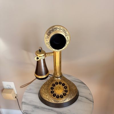 Sale Photo Thumbnail #133: Vintage Alexander Graham Bell replica candlestick telephone with ornate brass-finished housing and rotary-style push-button dial.