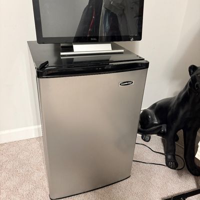Sale Photo Thumbnail #233: Franklin Chef stainless steel mini refrigerator topped with a Dell computer monitor.