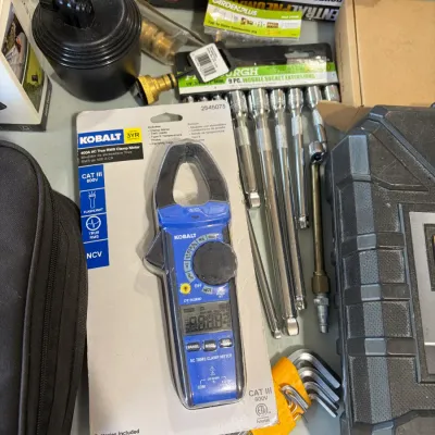 Sale Photo Thumbnail #14: Kobalt 400A AC True RMS clamp meter in original packaging, surrounded by assorted hand tools, socket extensions, and hex keys.